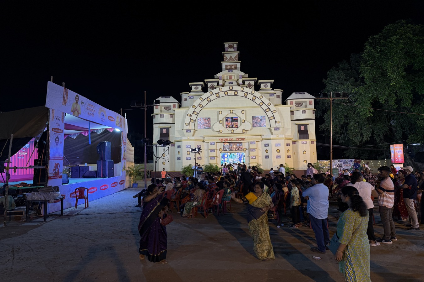 Large Durga Puja pandal with crowd and brand activation stage, Kolkata